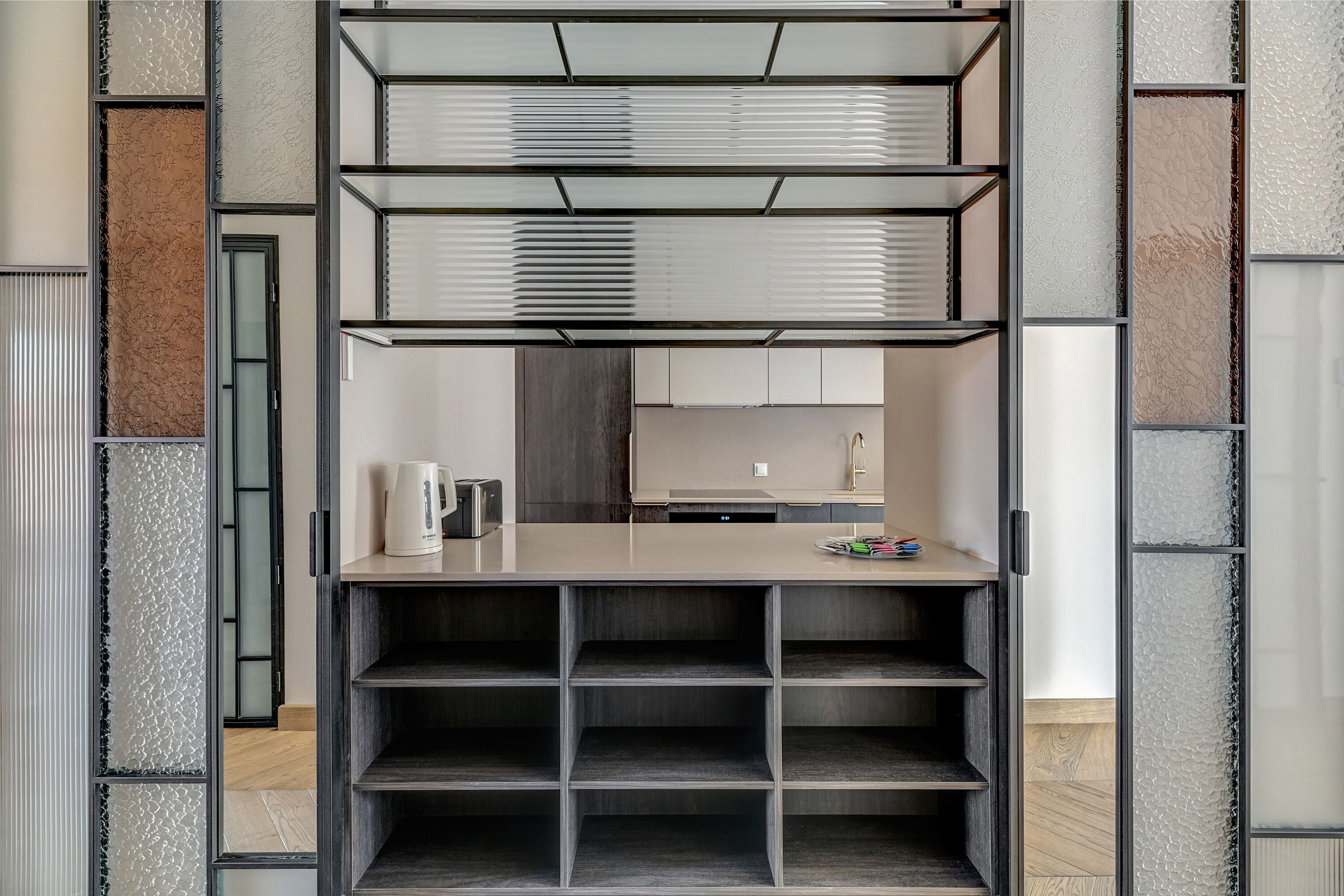 A compact kitchen with a built-in stove, a coffee maker, and a small countertop.