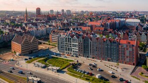 A modern building with a glass facade, surrounded by traditional European architecture. - Grano Apartments Gdańsk Residence (Gdansk)