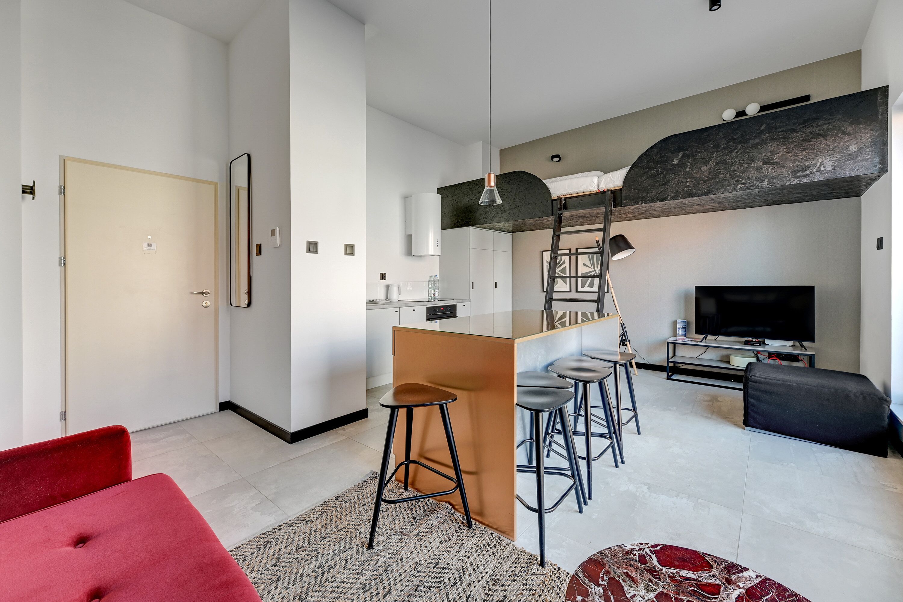 A modern living space with a kitchen, dining area, and seating area.