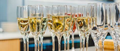 A bar area with multiple glasses of white wine on a tray.