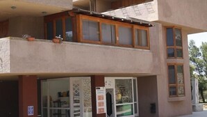A two-story building with a flat facade, large windows, and a balcony.