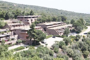 Un conjunto residencial con varias edificaciones, una zona de estacionamiento y zonas verdes circundantes.