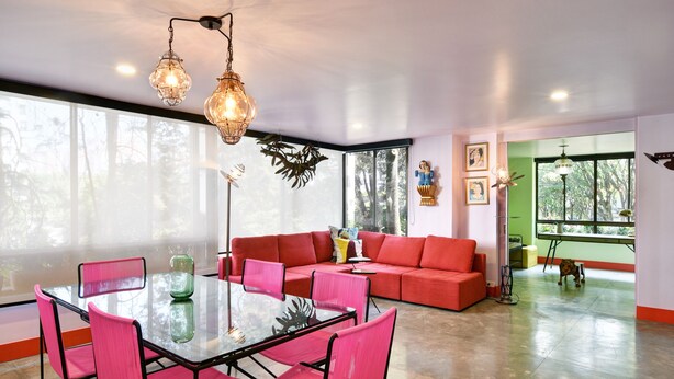 A modern living room with a glass table, pink chairs, a red sofa, and large windows. - Artsy Fun 5 minute walk to Parque Lleras  and Provenza (Medellín)