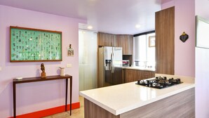 A modern kitchen with a central island, stainless steel appliances, and a decorative wall piece. - Artsy Fun 5 minute walk to Parque Lleras  and Provenza (Medellín)