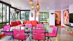 A modern living room with a glass table, red sofa, and pink chairs. - Artsy Fun 5 minute walk to Parque Lleras  and Provenza (Medellín)