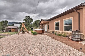Una propiedad residencial con un patio, un jacuzzi y un columpio de madera.