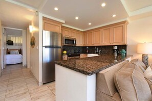 A modern kitchen with granite countertops, stainless steel appliances, and wooden cabinets.