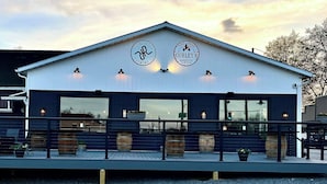 Um edifício com duas placas: "RISING RIVER BREWING CO." e "CURLEY'S BARBECUE".