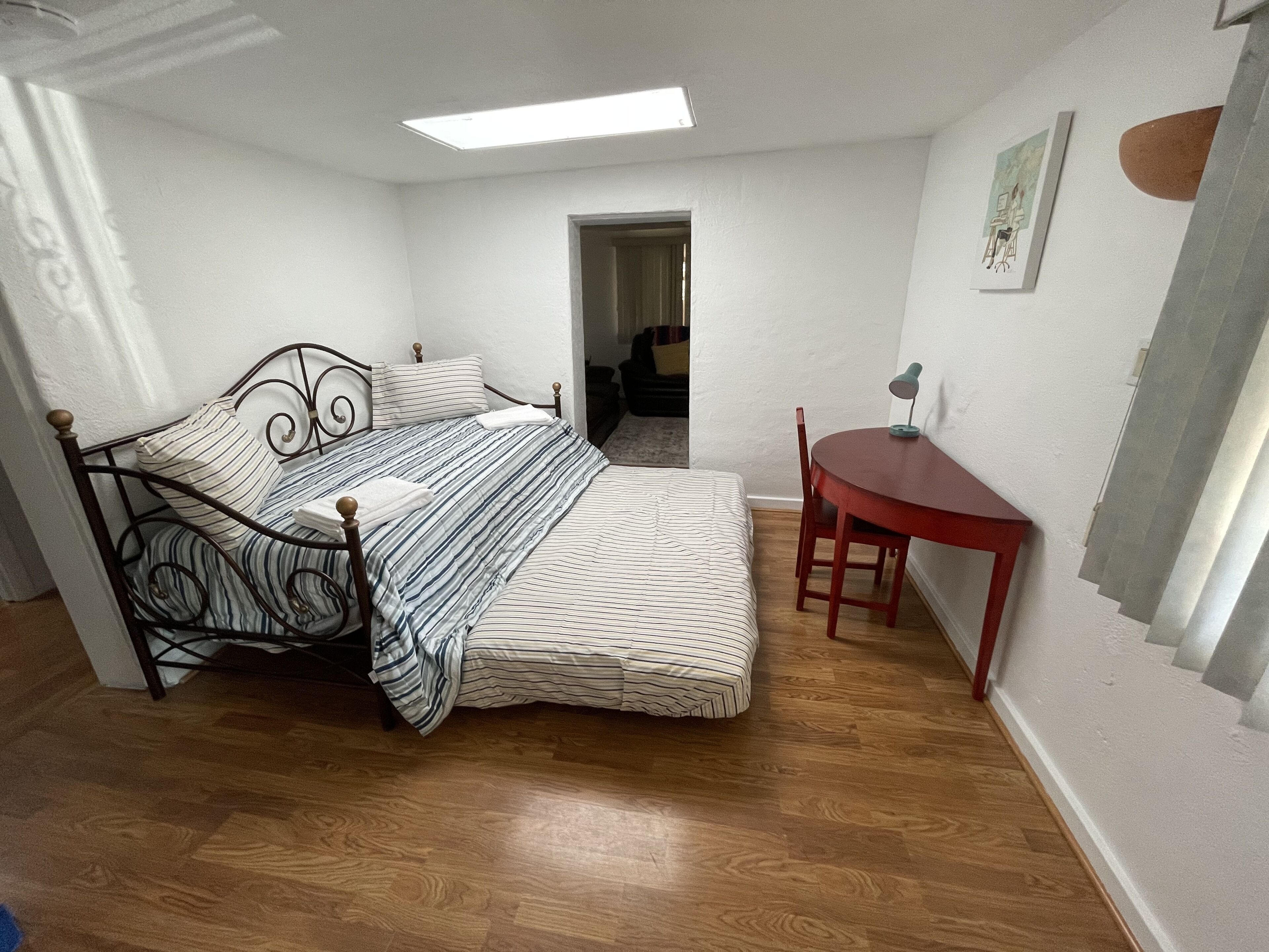 A bedroom with a bed, a desk, and a chair.
