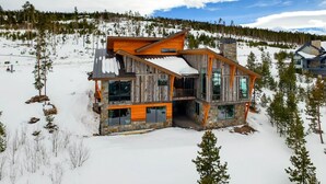 A modern log cabin with a stone chimney, large windows, and a snow-covered roof. - Colorado's Coolest Ski In/Out Home - World Class Mtn. Biking, Hiking & Fishing (Granby)