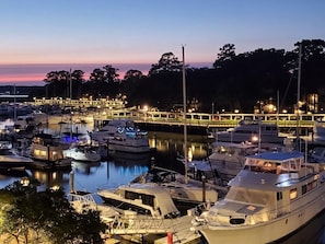 A marina at dusk with boats docked, a bridge in the background, and calm water reflecting the lights. - Fall/Winter Dates Are Open! Marina View, Central Location, Palmetto Dunes Access (Hilton Head Island)