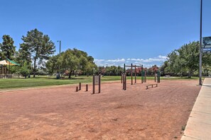 Guests can exercise and stay active in this outdoor fitness area surrounded by lush greenery and a paved walkway.