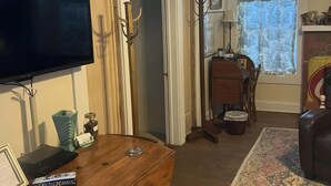Un salon avec une table basse en bois, un téléviseur à écran plat, une cheminée et un tapis à motifs.