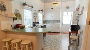 Une cuisine dotée d’un îlot central, de tabourets de bar, d’un four à micro-ondes et d’un réfrigérateur.