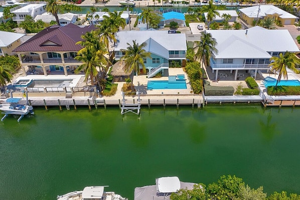 A coastal residential area with houses, a dock, and a swimming pool.