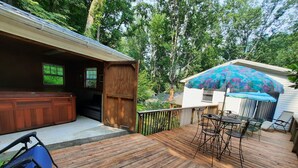 Une terrasse en bois avec des meubles d’extérieur, un espace salon couvert et un garage.