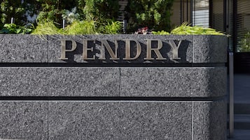 Une plaque en pierre sur laquelle est inscrit le mot « PENDRY » en grandes lettres, le tout entouré de verdure.