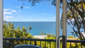 A balcony with a view of the sea and a clear sky.