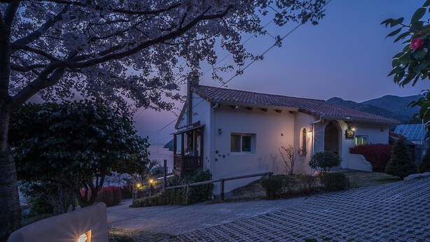 Una casa con tetto spiovente, un piccolo portico e un vialetto che conduce all'ingresso.