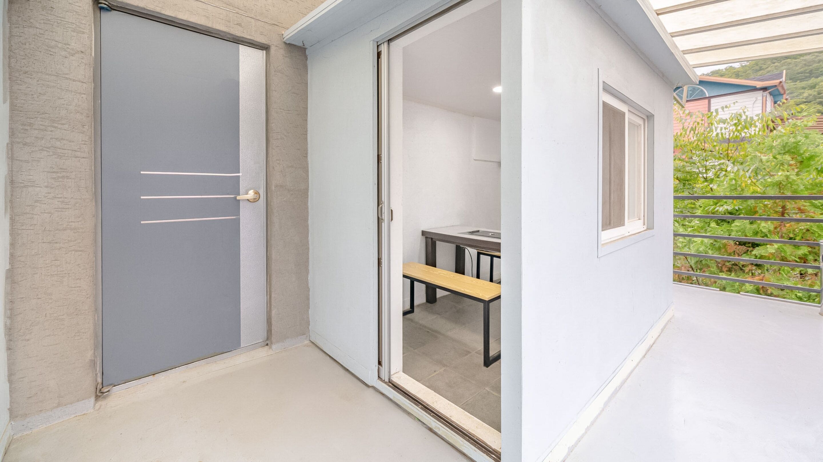 A modern room with a sliding door, a small table, and a bench.