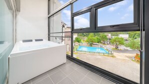 A balcony with a view of a swimming pool, a white washing machine, and a tiled floor. - Gapyeong Shiny Pension (Gapyeong)