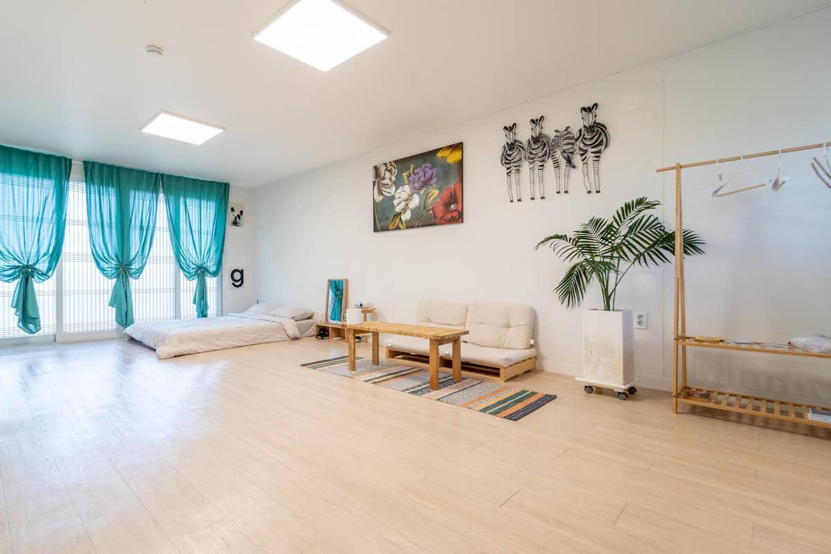 Un salon spacieux avec un canapé, une table basse et une grande fenêtre agrémentée de rideaux.