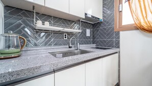 A modern kitchen with a granite countertop, stainless steel sink, and a built-in oven.