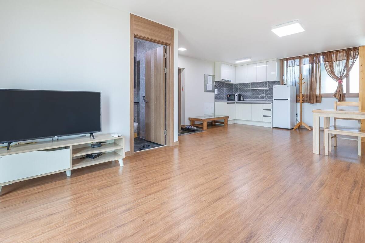 A modern apartment with a living room, kitchen, and dining area.