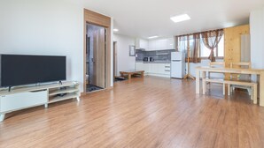A modern apartment with a living room, dining area, and kitchen.