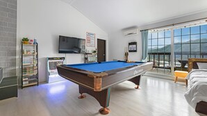 A modern hotel room with a pool table, a Game Box, a TV, and a balcony with a view. - Gapyeong Peulrei38 Pension (Gapyeong)
