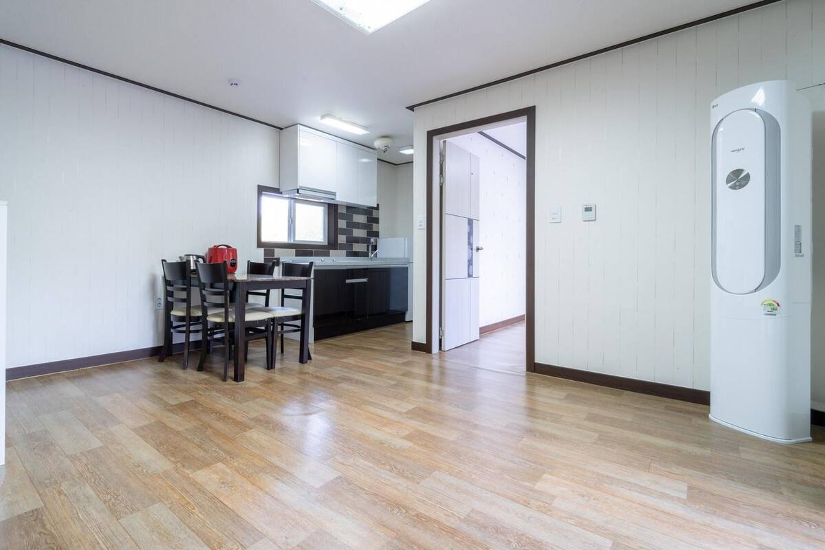 Una cocina moderna con comedor, calentador de agua y una puerta que da a otra habitación.