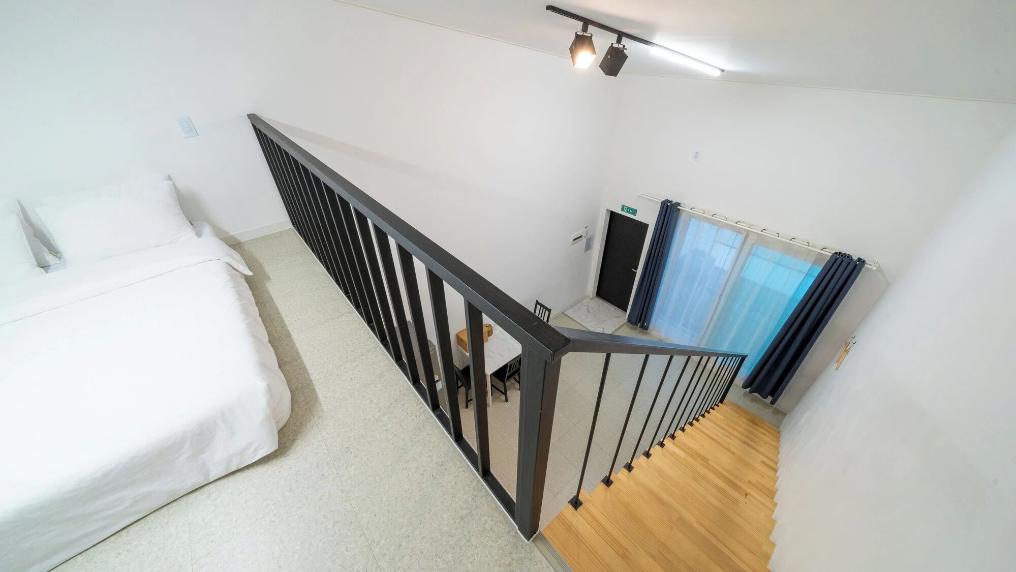 Een slaapkamer met een bed, een trap en een badkamer.