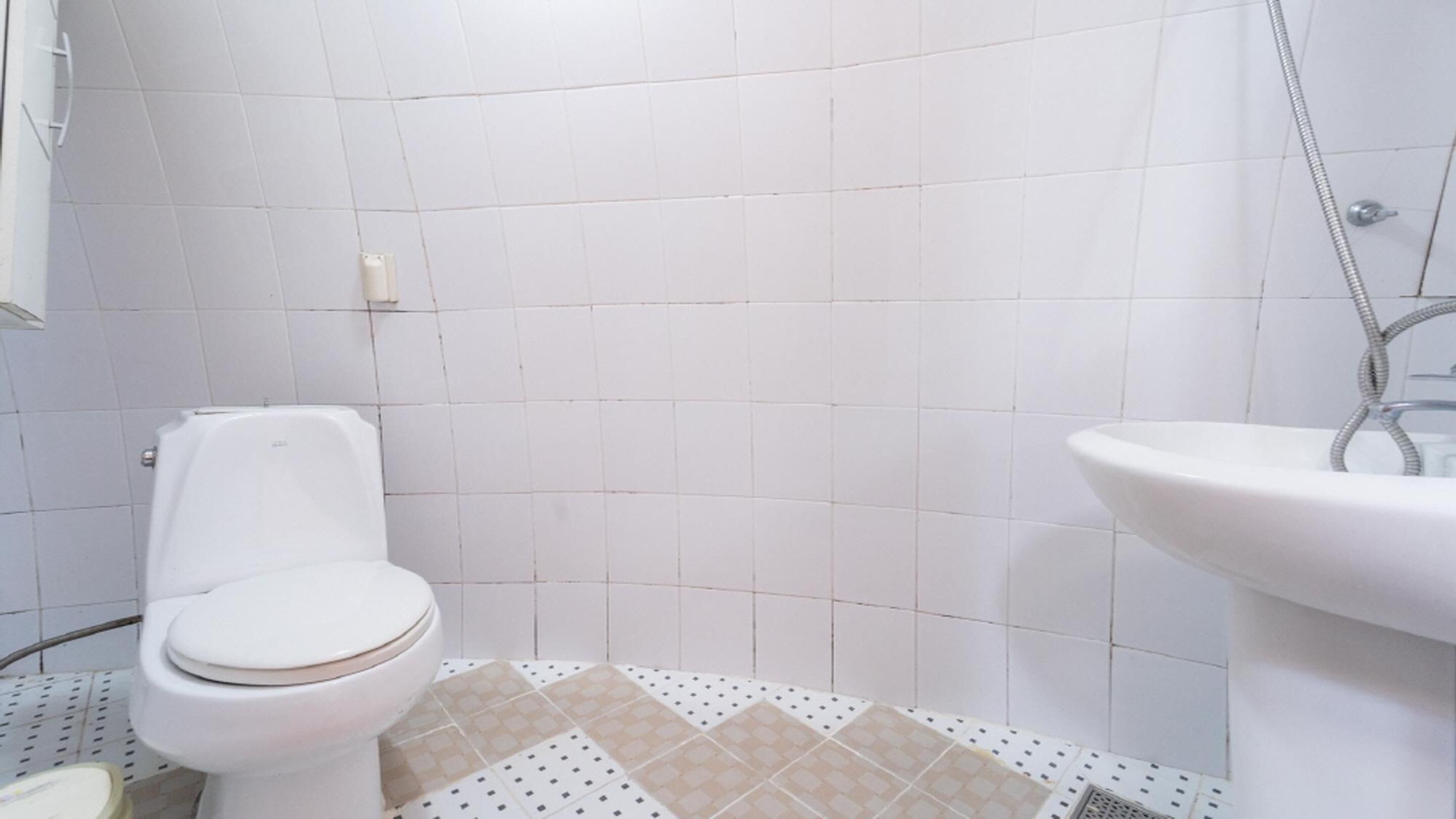 A bathroom with a toilet, sink, and shower.