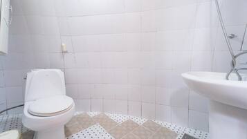 A bathroom with a toilet, sink, and shower.