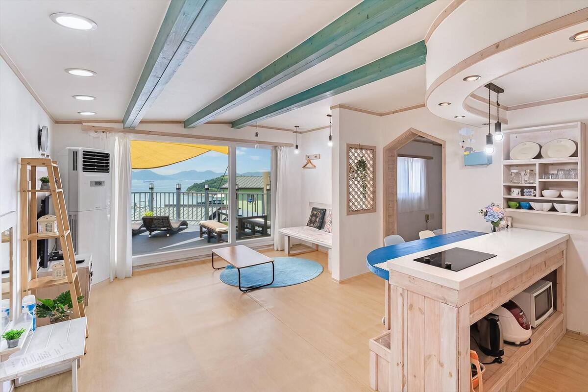 A modern kitchen with a built-in microwave, a wooden island, and a view of the outdoors.