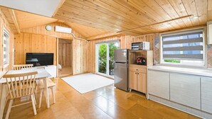 A wooden cabin with a kitchen, dining area, and a sleeping area. - Jeju Bijalim Pension (Jeju City)