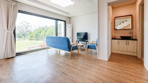 Un salon moderne avec un canapé, un téléviseur et un coin repas.