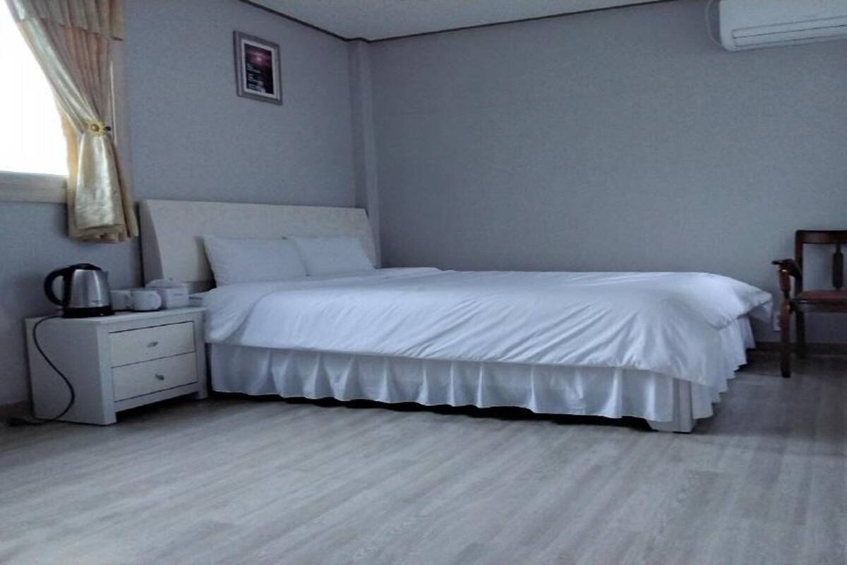 Une chambre à coucher avec un lit, une table de chevet et une chaise.