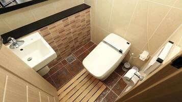 A small bathroom with a sink, toilet, and a wooden floor.