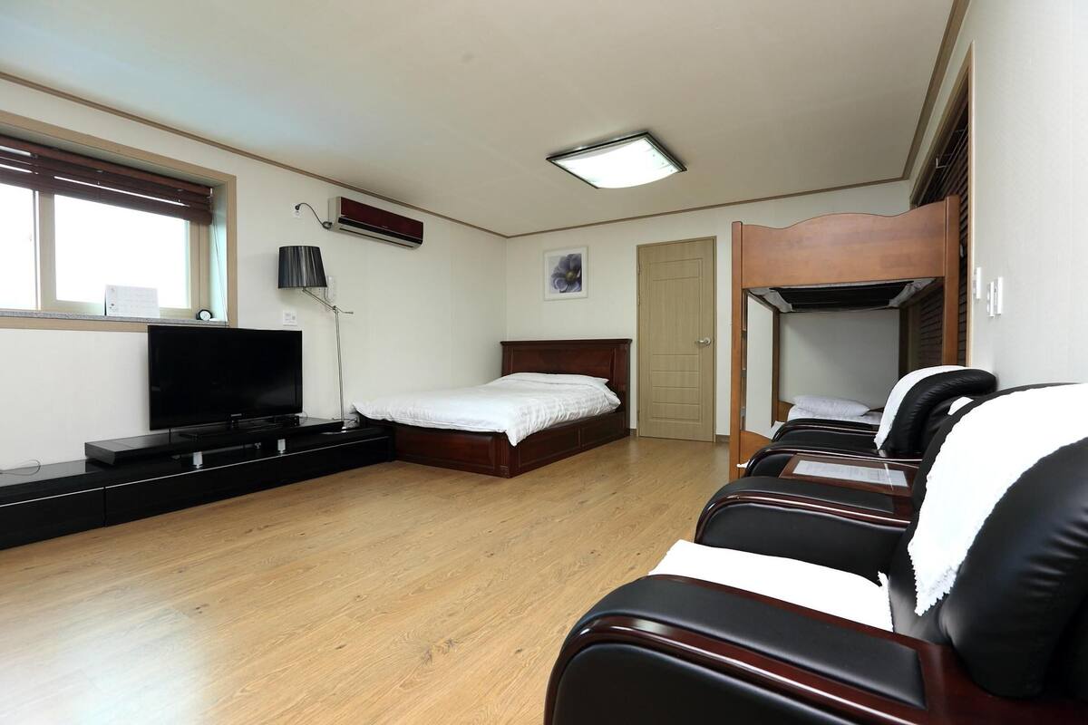 Une chambre d’hôtel avec un lit, une télévision, un bureau, une chaise et une fenêtre.