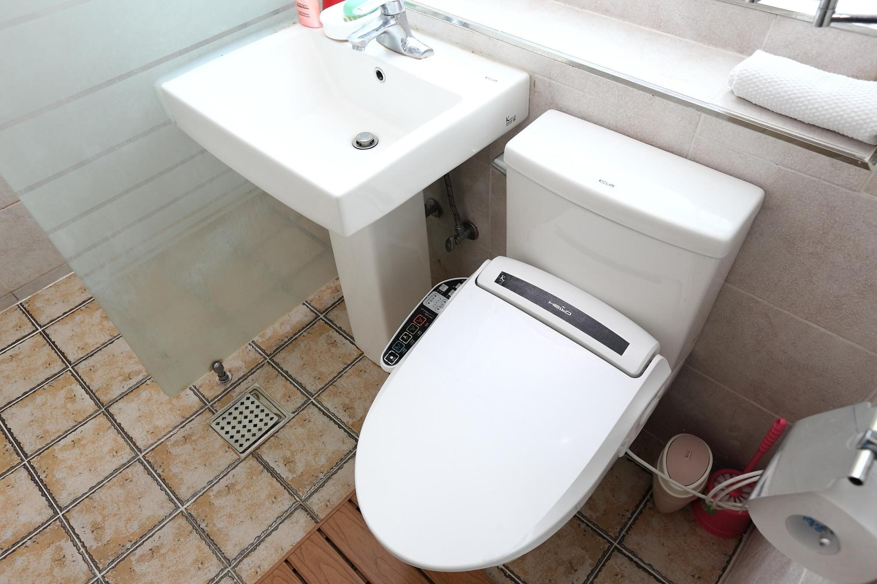 A bathroom with a white sink, toilet, and a bidet.
