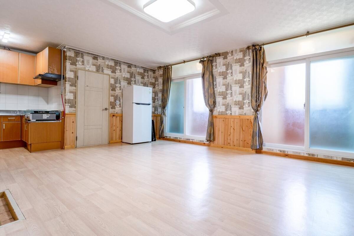 A spacious kitchen with wooden cabinets, a built-in oven, and a refrigerator.