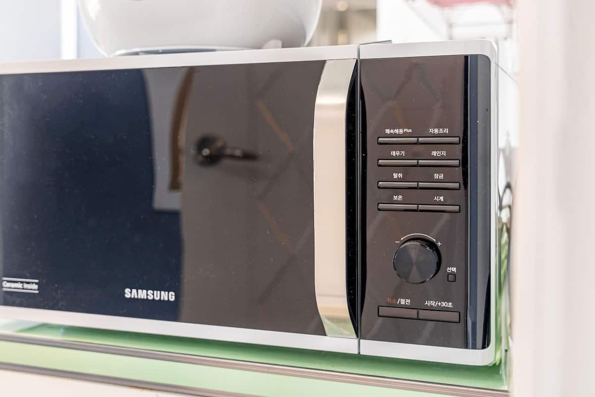 A Samsung microwave oven with a digital display, control panel, and a glass door.