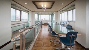 A conference room with a long table, chairs, and a railing. - Seogwipo Jejuhae-anhyuyang Pension (Seogwipo)