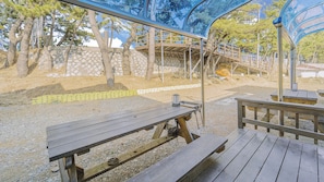 Un espacio al aire libre con mesas de picnic y un paseo techado.