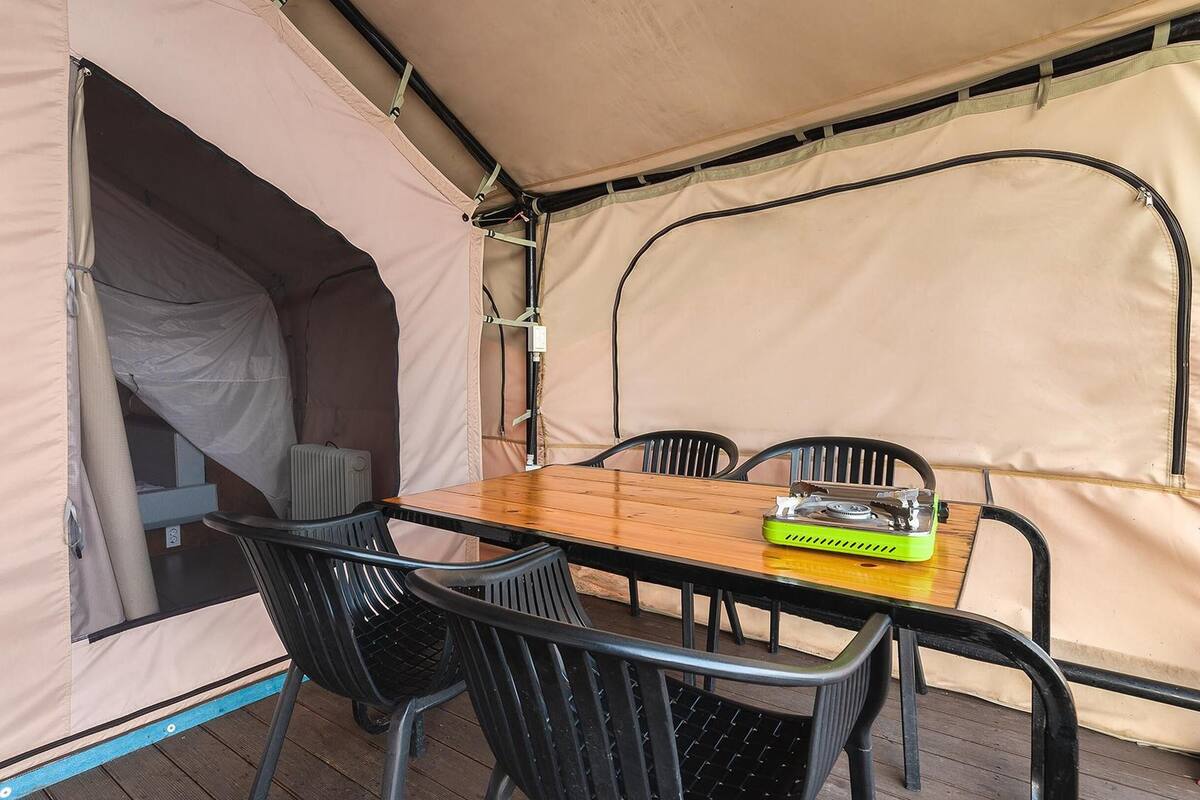 Una carpa con una mesa y sillas en su interior.