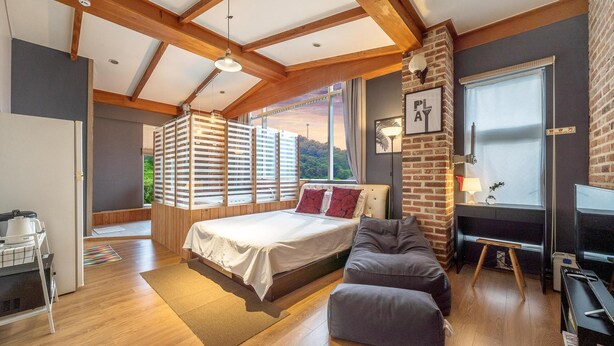 A bedroom with a bed, a desk, a chair, and a window with blinds. - Ganghwa Chocolate Pension (Incheon)