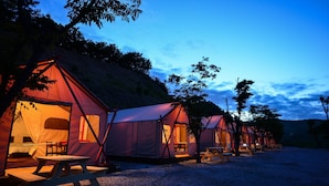 A row of tents with picnic tables and benches, set up in a campsite with a gravel ground. - Gwangneung Haeoreum Camping&glamping (Pocheon)