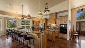 A spacious kitchen with a large island, wooden cabinets, and pendant lighting. - Paradise by the lake - Lonestar Lakehouse (Temple)