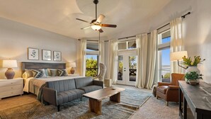 A bedroom with a bed, a sofa, a coffee table, a chair, a desk, a lamp, a plant, and a ceiling fan. - Paradise by the lake - Lonestar Lakehouse (Temple)